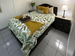 a bed with a blanket on it in a room at Casa Fortuna Near Luquillo Beach & El Yunque in Luquillo