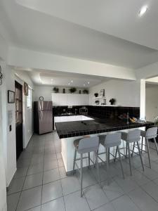 a kitchen with a counter and some chairs in it at Casa Fortuna Near Luquillo Beach & El Yunque in Luquillo