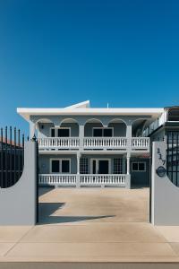 a large white building with a fence in front of it at Casa Fortuna Near Luquillo Beach & El Yunque in Luquillo