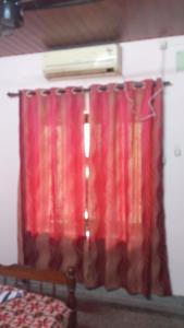 a red curtain in a room with a bed at New royal home stay in Varkala