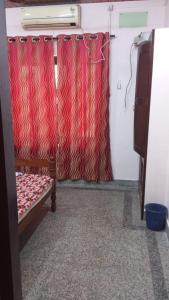 a room with a curtain and a bed in a room at New royal home stay in Varkala