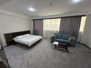 a bedroom with a bed and a blue couch at Rustaveli Inn რუსთაველი ინნ in Rustavi