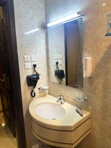 a bathroom with a sink and a mirror at فندق تاج الذهبية Taaj Alzahabiya Hotel - Al Rawda in Makkah +32 photos