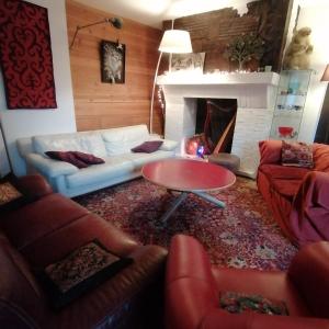 a living room with couches and a table and a fireplace at Les ateliers du Cucheron in Saint-Pierre-de-Chartreuse