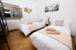 twee bedden in een kamer met witte muren bij Apartament La Plana in Campdevánol