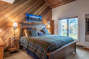 a bedroom with a bed and a wooden wall at 3 Bedrooms + Loft townhome in Snowcreek Phase 3, Private Pool Table Sleeps 6 Guests, Dog Friendly in Old Mammoth