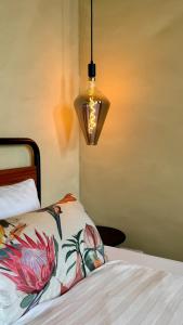 a bedroom with a bed and a lamp with a flowery blanket at Nordic Zen Loft mit Garten in Magdeburg