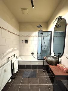 a bathroom with a bath tub and a sink at Nordic Zen Loft mit Garten in Magdeburg