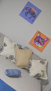 a bed with pillows and pictures on the wall at Flat 1778 N2 Orla Petrolina in Petrolina
