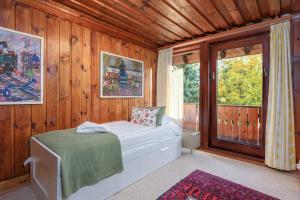 a bedroom with a bed and a large window at Altes Forsthaus Kniebis in Freudenstadt