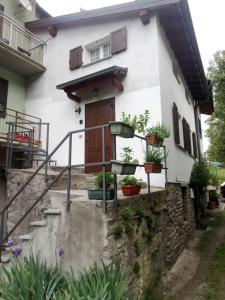 Una casa con plantas en macetas delante de ella. en Casa Liscidini, en Aprica