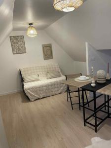 a bedroom with a bed and a table in it at Studio calme in Merlevenez