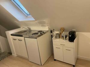 a small kitchen with a sink and a stove at Studio calme in Merlevenez