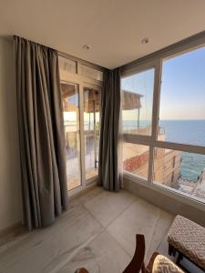 Una habitación con una gran ventana con vista al mar. en Sea View Romantic Rooftop, en Alejandría