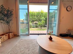 a room with a wooden table and a large window at Jomo Stay Takasaki 2 -the Garden- in Takasaki