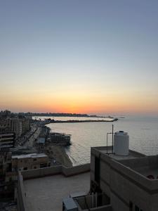 desde un edificio con vistas al océano al atardecer en Sea View Romantic Rooftop, en Alejandría