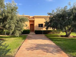 a walkway in front of a house with a tree at Olead in Aghmat