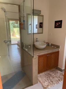 Un baño con lavabo y ducha de cristal. en Olead, en Aghmat