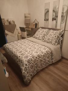 a bedroom with a bed with a black and white comforter at Chambre d hôte chez l habitant in Meyzieu