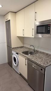 a kitchen with a sink and a washing machine at Apartamento Los Olivos in Huesca +13 photos
