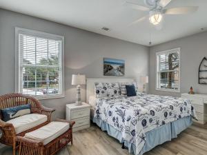 a bedroom with a bed and a chair and windows at Life's a Beach in Tybee Island +37 photos