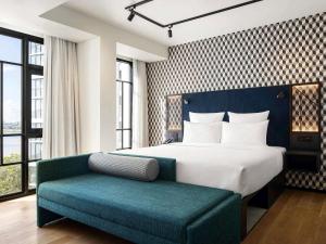 a bedroom with a bed and a blue bench at TRIBE Phnom Penh Post Office in Phnom Penh +131 photos