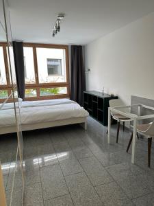 a bedroom with a bed and a table and a window at Bergstudio II I Flims I Laax I Ski I Caumasee in Flims +7 photos