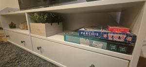 a white cabinet with books and boxes on it at Manzaneda Natura Apartments T1 in Puebla de Trives