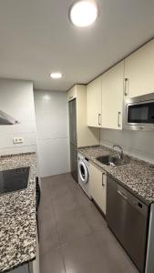 a kitchen with a sink and a washing machine at Apartamento Los Olivos in Huesca