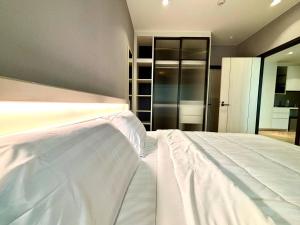 a large white bed in a room with at The Legendary Bang Tao 2-bedrooms apart #402 in Bang Tao Beach