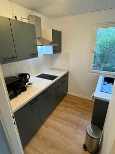 a kitchen with gray cabinets and a window in it at Feriendorf Seddiner See - Bungalow 8 in Seddin