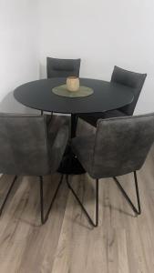 霍恩-巴特迈恩贝格Cozy apartment in Horn-Bad Meinberg!的一张黑色的桌子，上面放着两把椅子和一顶帽子 更多13张照片