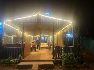 a tent with lights on it at night at water front guest house in Arambol