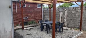 a patio with a table and chairs under a pergola at Wooden Kaz, Meublé de tourisme 2 étoiles in Le Moule