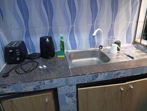 een aanrecht met een wastafel en een fles zeep bij Entire 1 Bedroom flat in Lagos in Orile