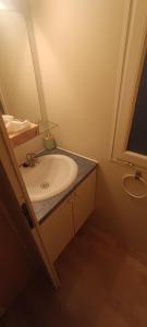 a bathroom with a sink and a mirror at Family mobile home solar powered near the sea and the airport in Áyios Spirídhon +23 photos