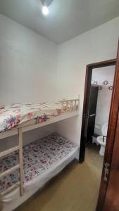 a bedroom with two bunk beds and a toilet at Perto do peixe Marley - Praia do Morro in Guarapari