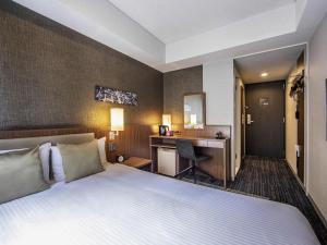 a hotel room with a bed and a desk at ibis Styles Tokyo Ginza in Tokyo