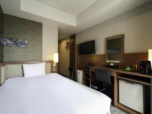 a hotel room with a large bed and a desk at ibis Styles Tokyo Ginza in Tokyo