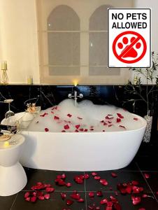 a bathroom with a bath tub with red roses on the floor at 24Rooms นครสวรรค์ in Nakhon Sawan