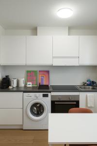 a white kitchen with a washing machine in it at Cozy apartment Écusson - Montpellier in Montpellier