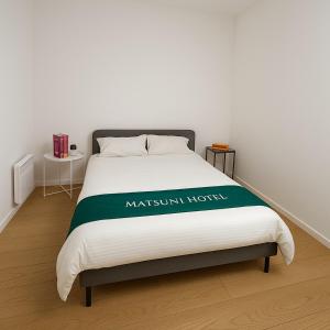 a bed with a green and white blanket on it at Cozy apartment Écusson - Montpellier in Montpellier