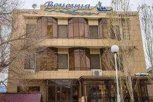 a building with a sign on the side of it at Mini Hotel Venezia in Atyrau