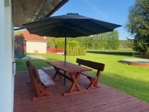a picnic table and two chairs with an umbrella at Nature Escape Cottage in Protivín