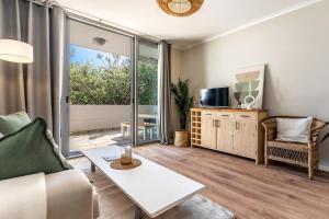 a living room with a couch and a table at Melrose Tide 1 Bed Spacious Apartment in Muizenberg