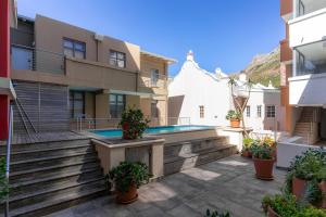 a courtyard of a house with a swimming pool at Melrose Tide 1 Bed Spacious Apartment in Muizenberg