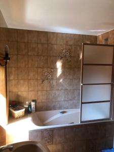 a bath tub in a bathroom with a mirror at Gîte de la Croix Mandet in Vensat