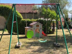 a swing set in a yard with a house at Gîte de la Croix Mandet in Vensat
