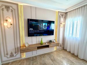 a living room with a television on a wall at Reda's Apparts centre ville wifi 200 Mo in Fès