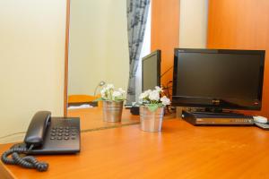a desk with a telephone and a television on it at Mini Hotel Venezia in Atyrau